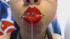 Jouer Une ado aux lèvres rouge vif crache et bave dans une action chaude de jeune bouche